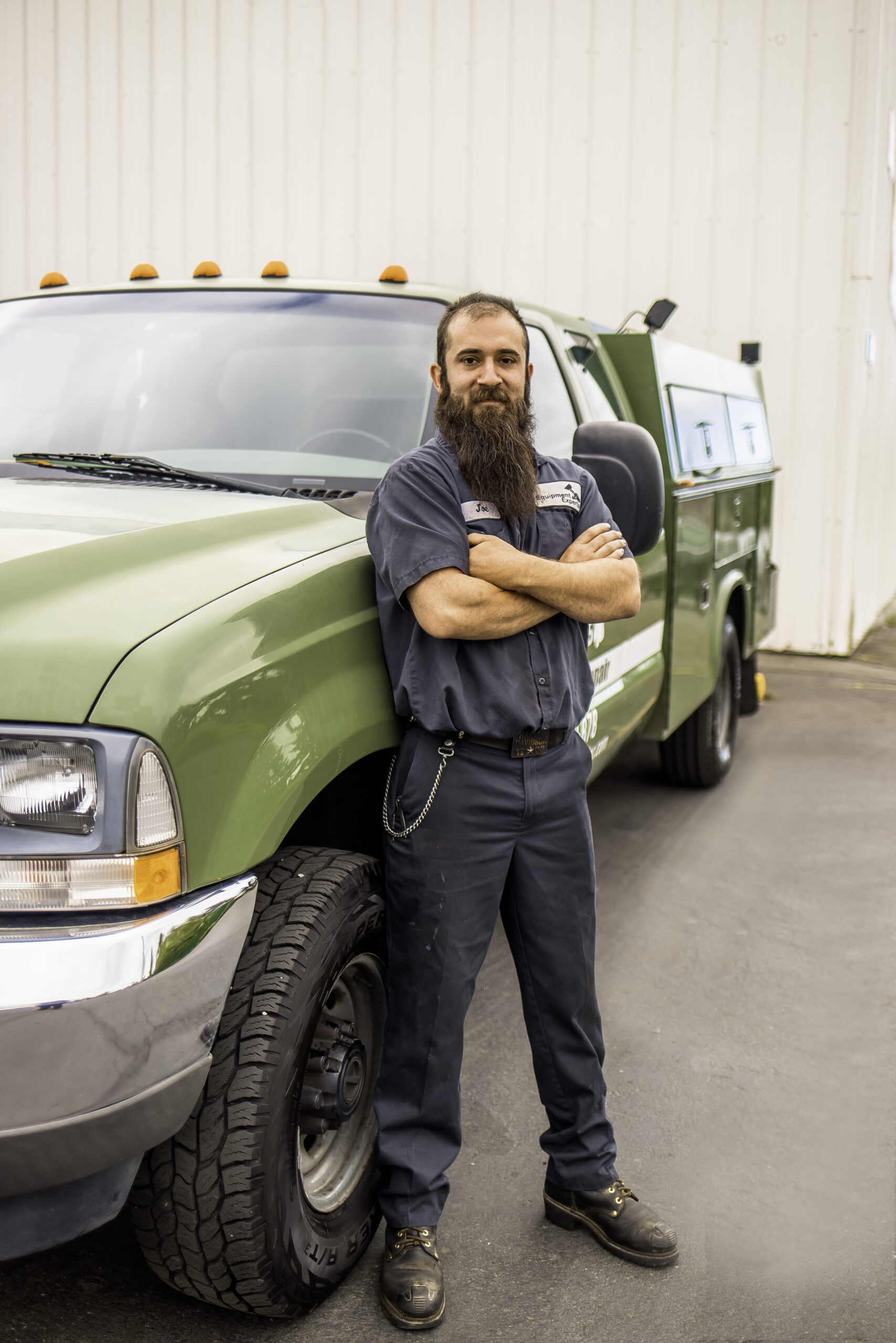 A fleet vehicle driver, Joe, in front of an Equipment Experts, Inc. truck