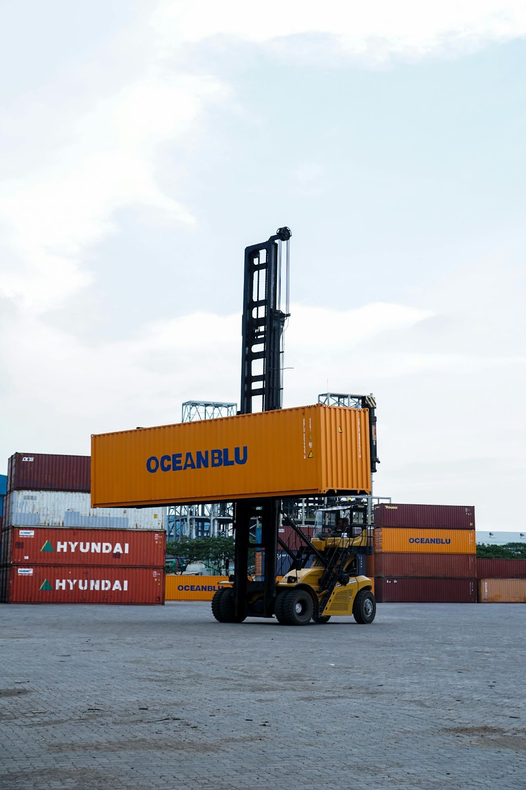 An industrial forklift carrying and stabilizing a shipyard crate