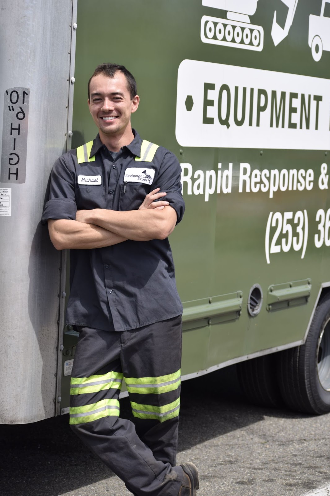 A picture of an Equipment Experts Inc. employee standing in front of a truck