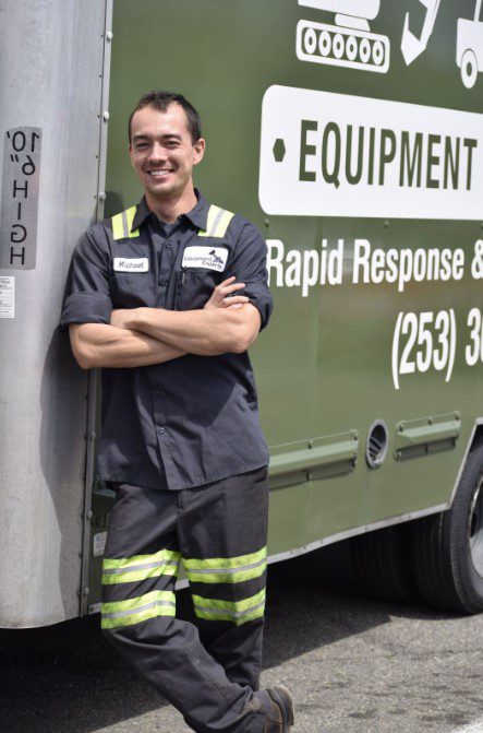 Equipment Experts team member leaning against a service truck and smiling