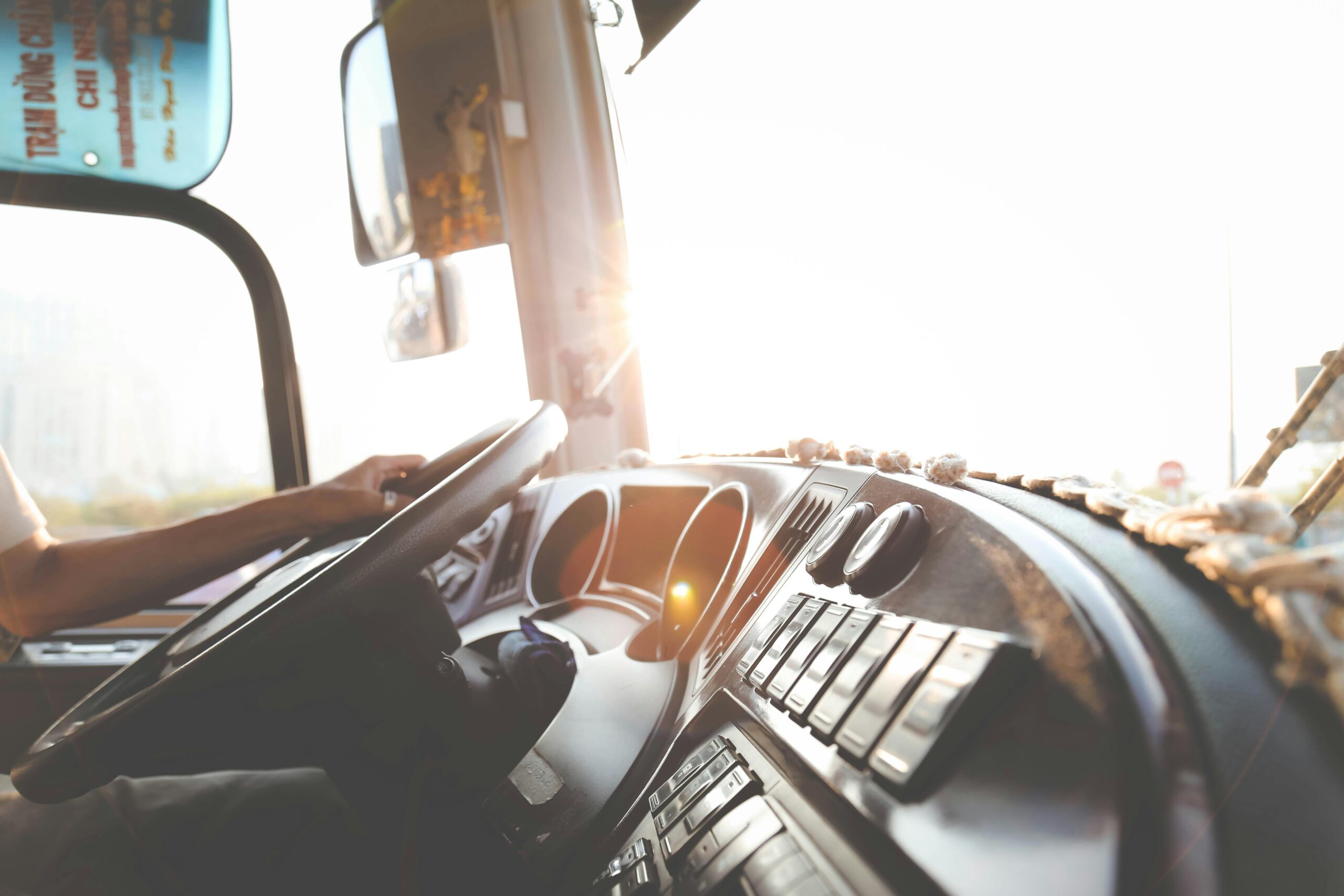 Truck dashboard interior with hands on the steering wheel and gauges visible