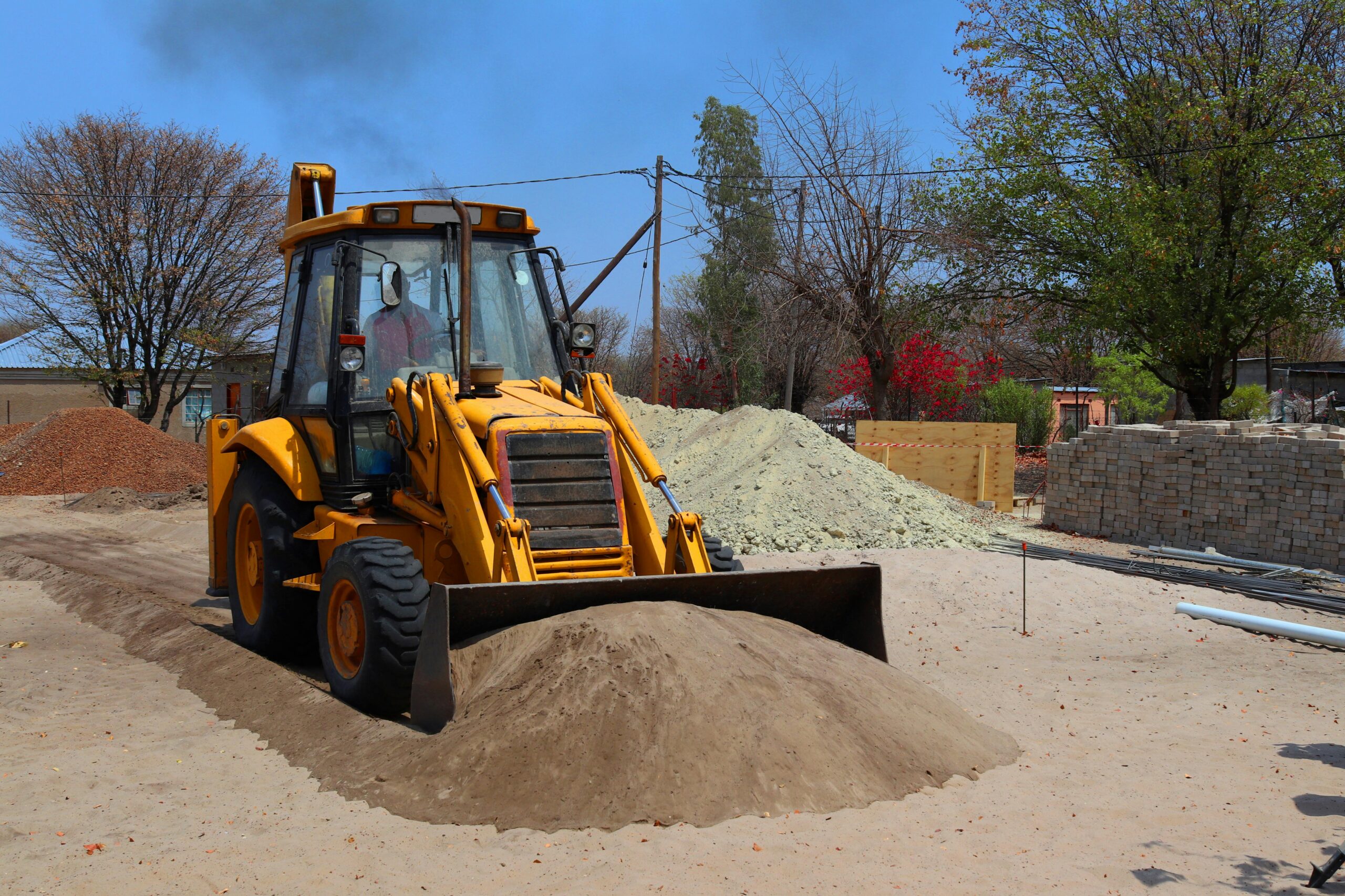 An excavator scooping up sand