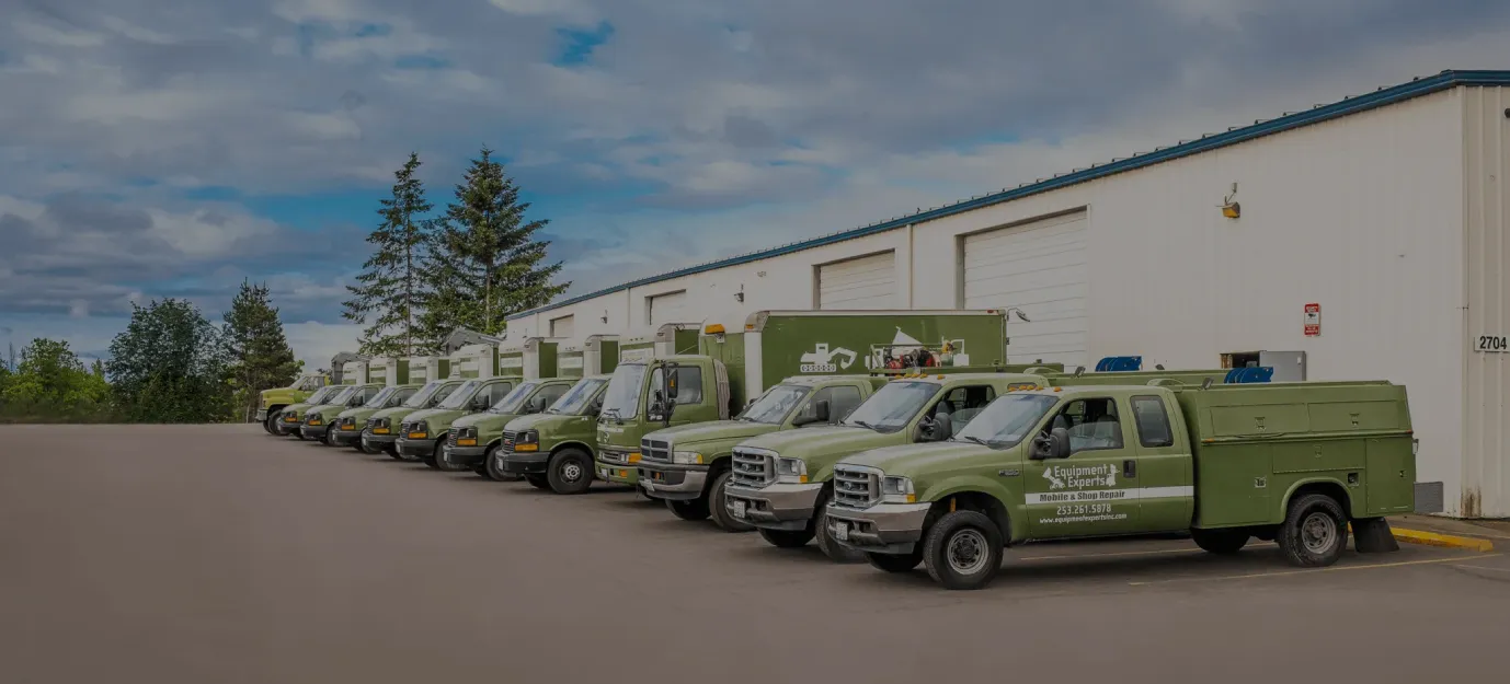 Fleet of green Equipment Experts service trucks lined up outside a building