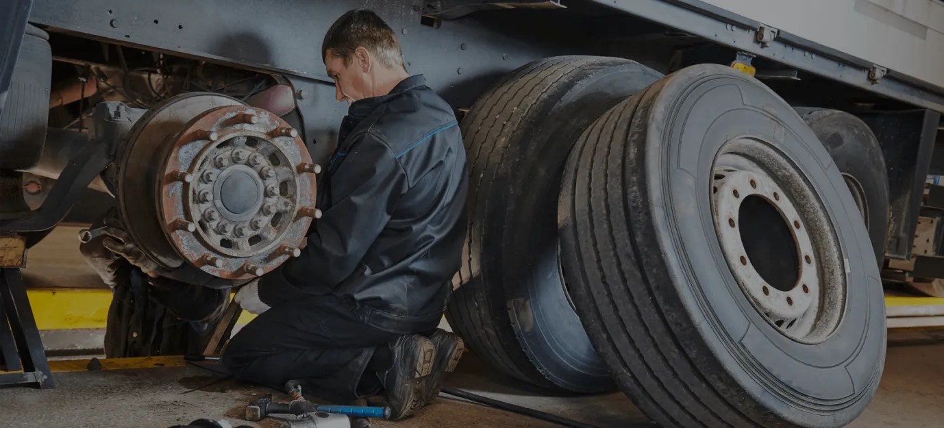 Mechanic removing a truck wheel assembly during repair