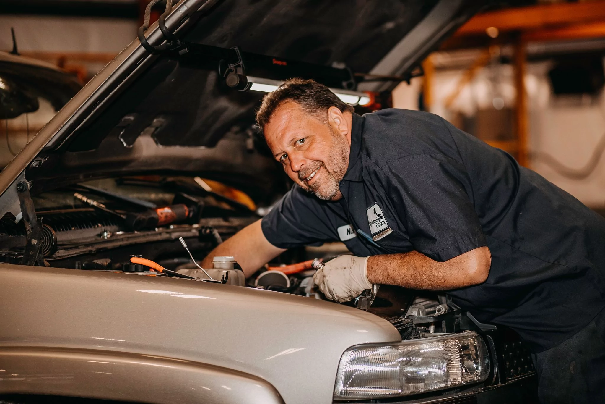 Equipment Experts, Inc. employee smiling at the camera with their hands in a truck